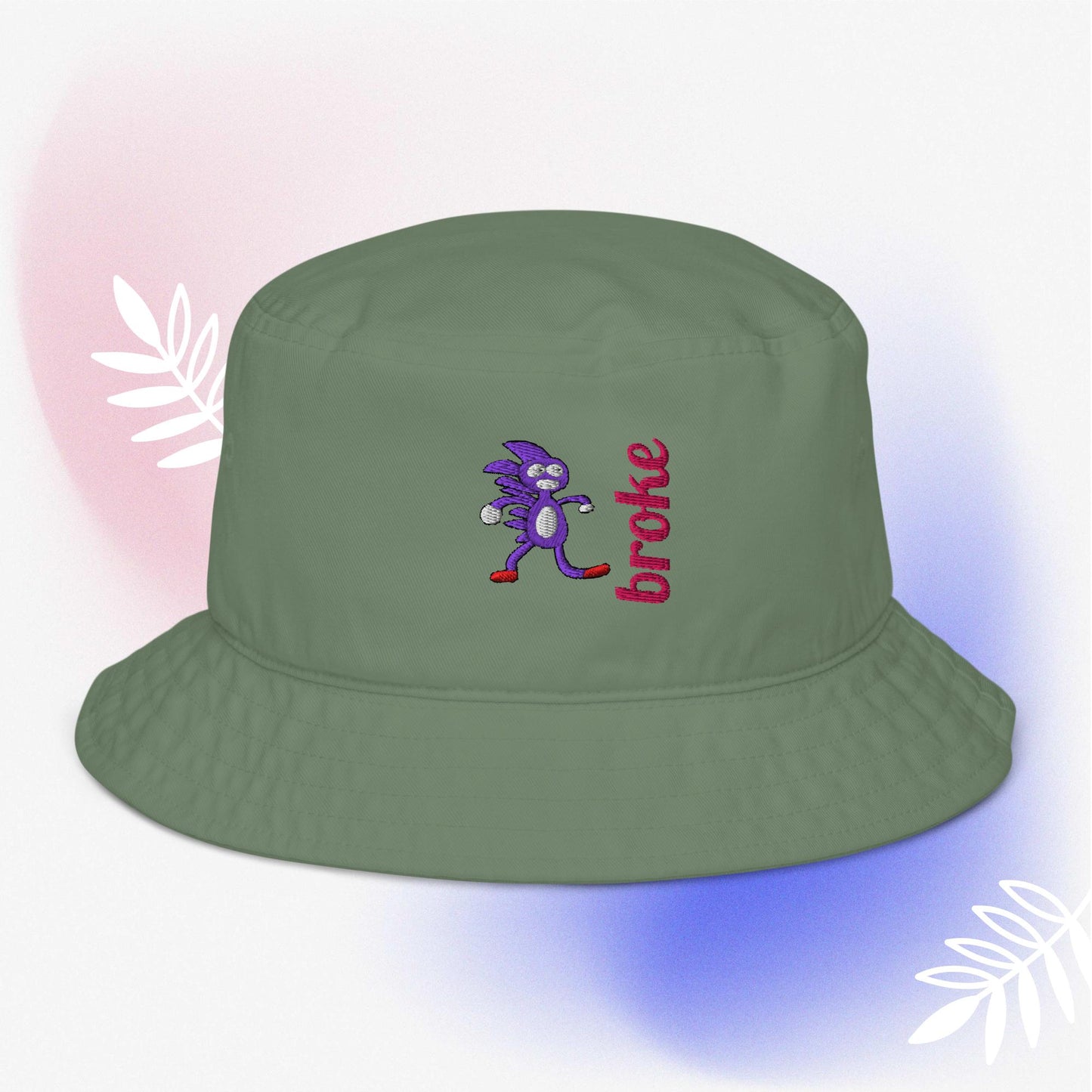 Beige bucket hat featuring a purple Sanic embroidery, a quirky version of Sonic the Hedgehog, alongside the word 'broke' stitched in bold red. Perfect for meme culture fans and streetwear enthusiasts looking for a playful and trendy accessory.