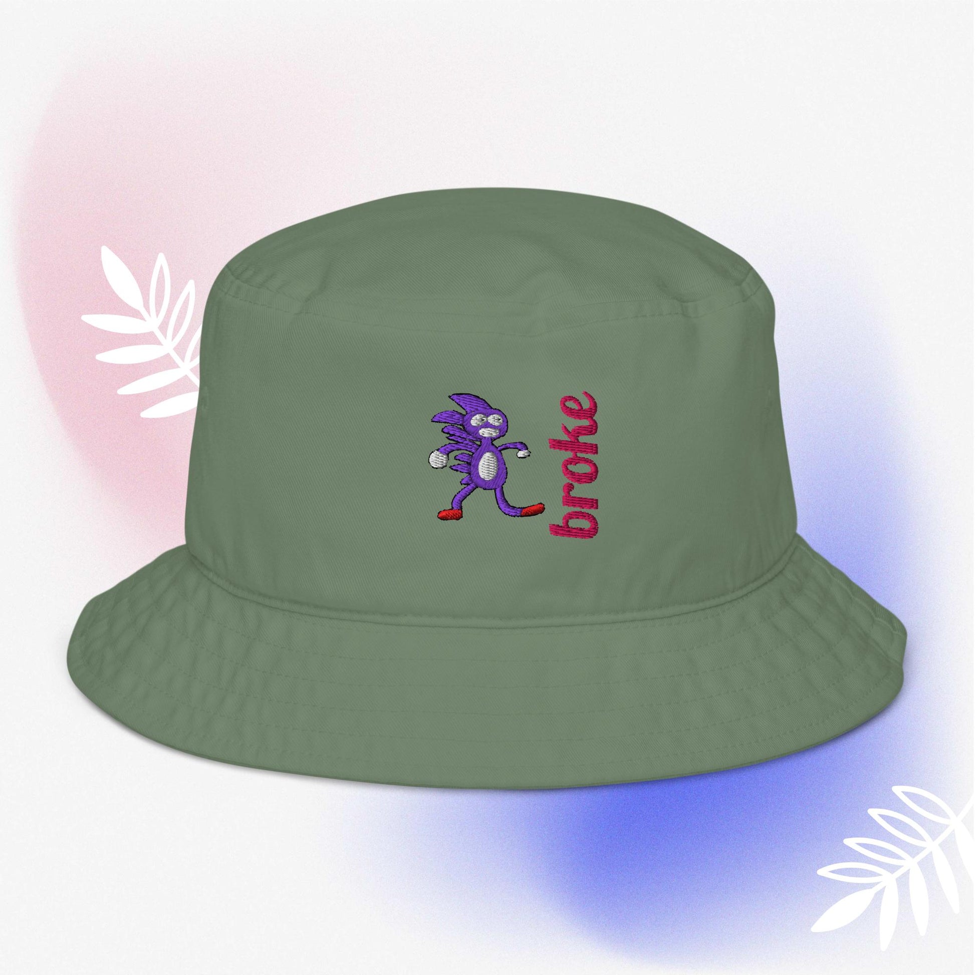 Beige bucket hat featuring a purple Sanic embroidery, a quirky version of Sonic the Hedgehog, alongside the word 'broke' stitched in bold red. Perfect for meme culture fans and streetwear enthusiasts looking for a playful and trendy accessory.