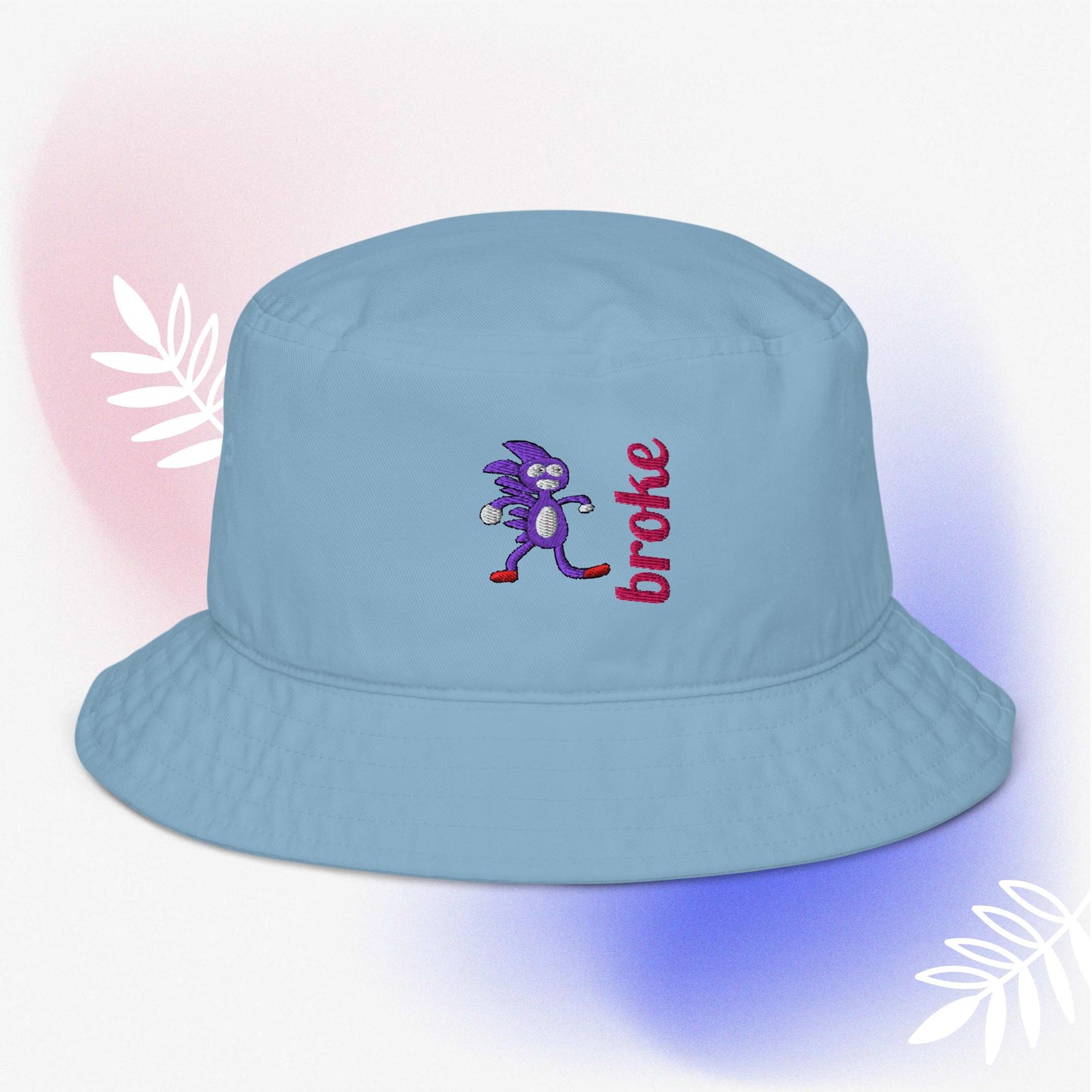 Beige bucket hat featuring a purple Sanic embroidery, a quirky version of Sonic the Hedgehog, alongside the word 'broke' stitched in bold red. Perfect for meme culture fans and streetwear enthusiasts looking for a playful and trendy accessory.