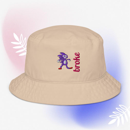 Beige bucket hat featuring a purple Sanic embroidery, a quirky version of Sonic the Hedgehog, alongside the word 'broke' stitched in bold red. Perfect for meme culture fans and streetwear enthusiasts looking for a playful and trendy accessory.