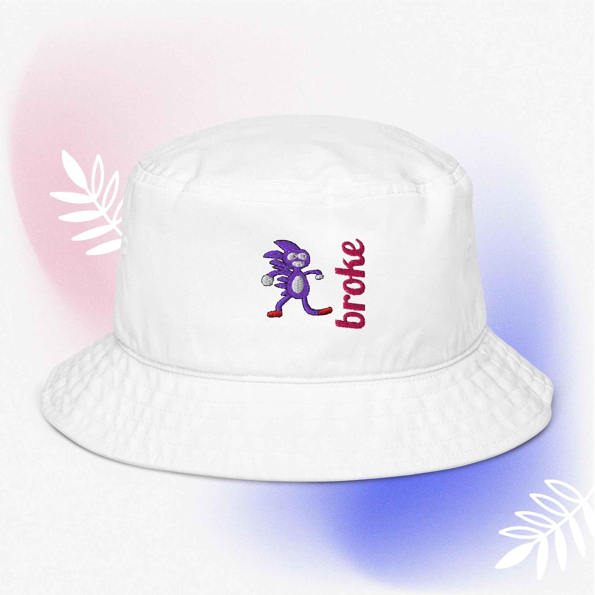 Beige bucket hat featuring a purple Sanic embroidery, a quirky version of Sonic the Hedgehog, alongside the word 'broke' stitched in bold red. Perfect for meme culture fans and streetwear enthusiasts looking for a playful and trendy accessory.